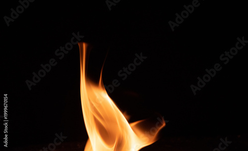 Fire flame on a dark background. Yellow tongues of fire in the fireplace. Flames concept.