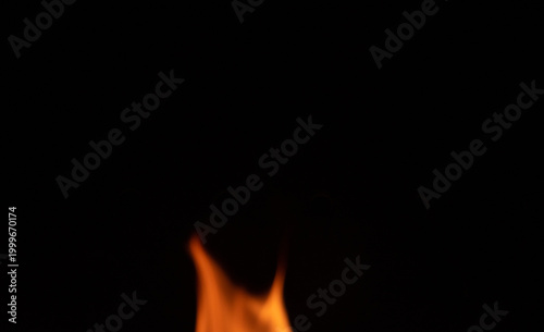Fire flame on a dark background. Yellow tongues of fire in the fireplace. Flames concept.