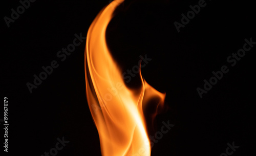 Fire flame on a dark background. Yellow tongues of fire in the fireplace. Flames concept.