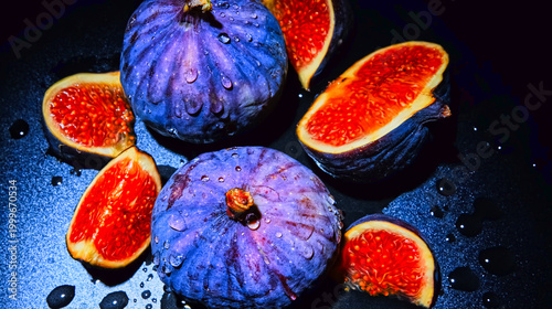 Fresh purple figs with water droplets on a dark background