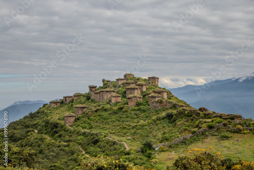 Ancient stone structures on mountain peak with dramatic sky landscape