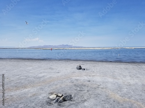Expansive view of the Great Salt Lake shoreline under a bright blue sky.