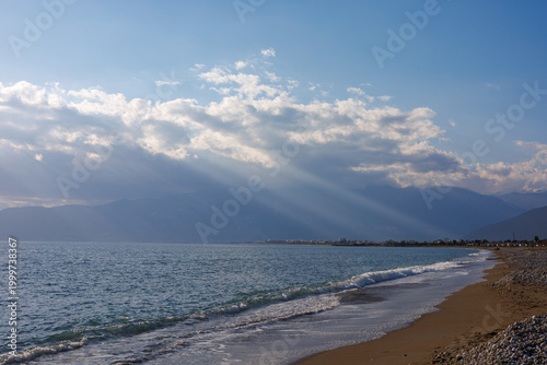 Sunlit rocky beach at sunset with crepuscular rays