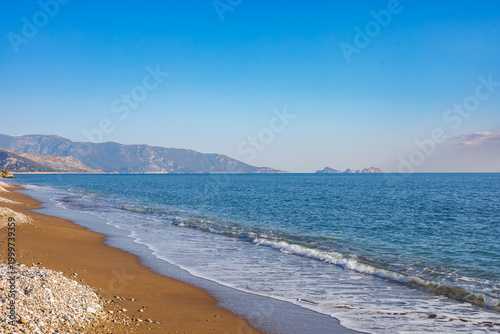 Sunlit sandy beach by the sea at sunset