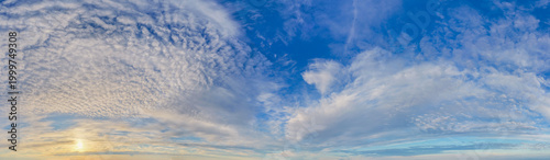 Panoramic Cloudscape at Sunrise With Blue Sky and Textured Wispy Clouds Over Horizon