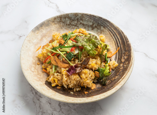 Photography Delicious bowl of mixed rice salad with vegetables and herbs on a marble surface