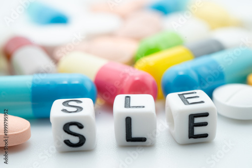 SLE systemic Lupus erythematosus or Lupus word with pills and capsules medical drug.