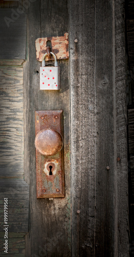 The image features a rustic wooden door with a rusty doorknob and padlock. Weathered textures and peeling paint highlight its age.