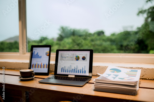 Professional woman working on laptop in café, enjoying hot drink break, smiling thoughtfully, balancing productivity, comfort, and modern lifestyle.
