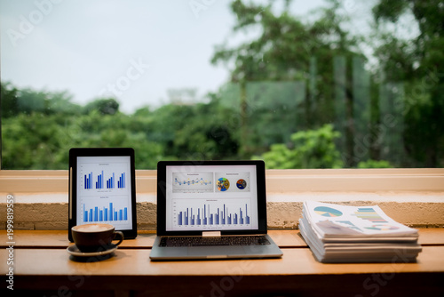 Professional woman working on laptop in café, enjoying hot drink break, smiling thoughtfully, balancing productivity, comfort, and modern lifestyle.
