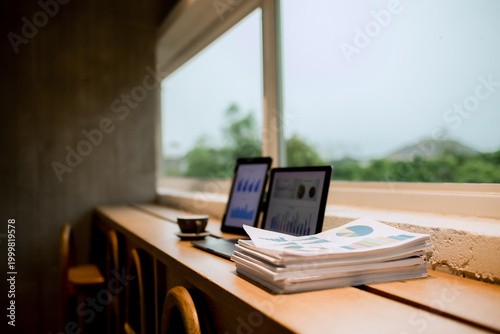 Professional woman working on laptop in café, enjoying hot drink, reviewing charts, planning projects, and staying focused in modern business lifestyle.

