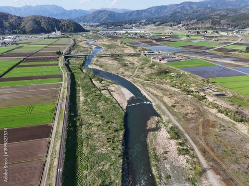 Aerial view of a winding river through green farmland