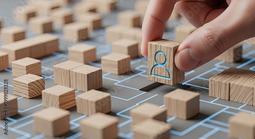 Hand placing wooden person block into digital grid gap