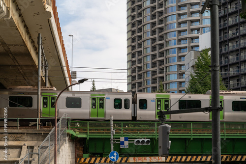 Train passing over a bridge in a modern Japanese city