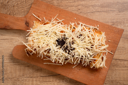 Roti Bakar Keju, Sandwich Bread Toast with Shredded Cheese. Popular Street Food from West Java. Perfect for recipe, article, catalogue, or any commercial purposes. with copy space.