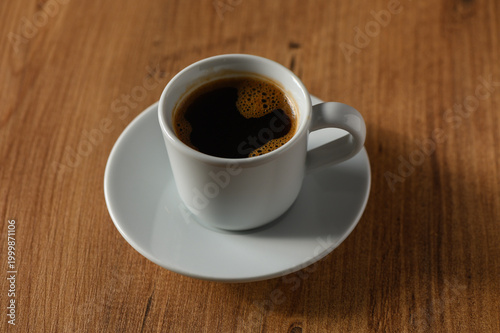 A cozy coffee moment captured in a serene cafe with warm wooden tones in the early morning light