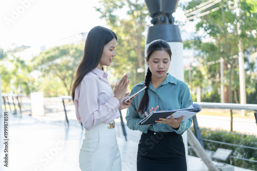 Two businesswoman work taking outside office