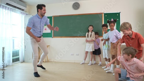 Diverse group of school children enjoying dance activity with teacher in an international classroom, encouraging active learning and teamwork