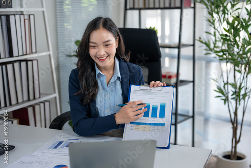 Fotografía Smiling young businesswoman presenting financial data online