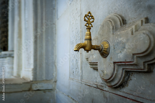 Fotografija Antique brass faucet on ablution fountain in Ottoman mosque, Istanbul, Turkey