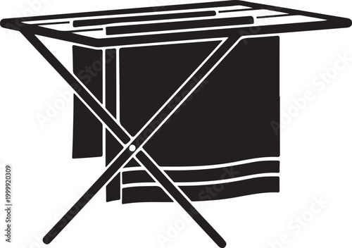 Black and white of a folding laundry drying rack with a towel hanging over the metal frame rails