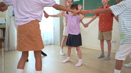 Diverse group of school children enjoying dance activity with teacher in an international classroom, encouraging active learning and teamwork