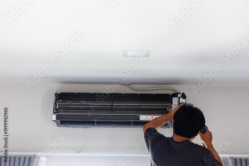 Maintenance technician performing professional air conditioning cleaning and service for a wall-mounted unit.