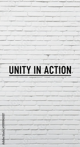 Black sans serif text proclaiming unity in action centered on a textured white painted brick wall background