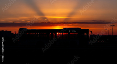 Silhouette of a Bus Against a Vibrant Sunset Sky.