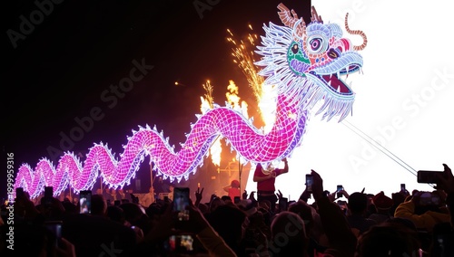 Colorful illuminated dragon at nighttime festival with crowd watching isolated on white background
