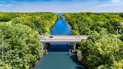 Aerial drone view of cars crossing bridge over river, forest landscape and modern road bridge, transportation and infrastructure in the Netherlands