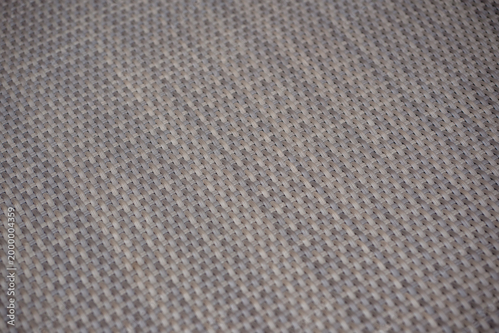 Fototapeta premium Grey woven rattan wicker texture background. Close up of synthetic polyrattan furniture surface pattern for abstract design.
