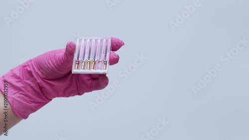 Dentist in Pink Gloves Extracting Endodontic File with Tweezers