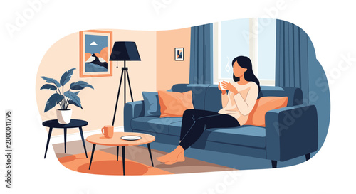 Elegant woman sits on a comfortable blue sofa by a window and enjoys a hot cup of coffee in a bright, modern living room.