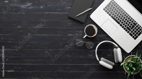 Modern Workspace with Laptop, Headphones, and Coffee on Dark Wooden Desk for Creative Professionals