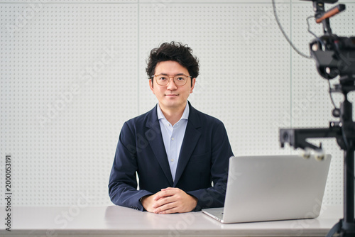 Fotografie 撮影スタジオでニュースの配信をする30代のフリーのアナウンサーの男性