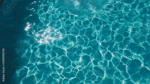 Sunlight reflecting on the clear blue water surface of a swimming pool