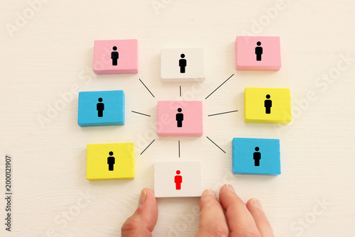 Wooden cubes and hand picking the leader. Idea of collaboration and teamwork