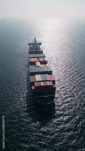 Aerial view of a large container ship in the open sea at sunset