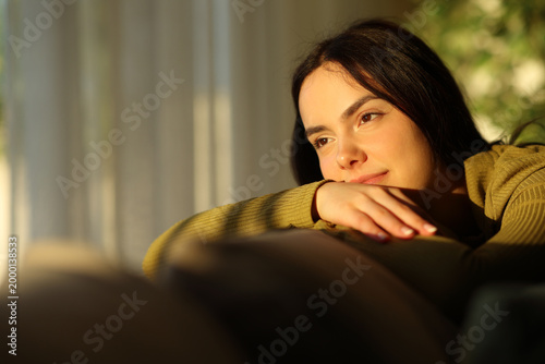Cuadro en lienzo Confident and satisfied woman relaxing contemplating sunset at home