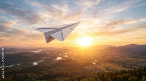 Paper Plane Soaring Over Mountain Landscape During Sunrise