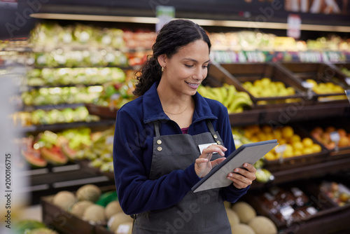 Store worker using tablet at supermarket