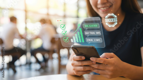 Successful young woman using smartphone with holographic interface showing business growth strategy goal achievement target kpi and progress bars for professional development and career success