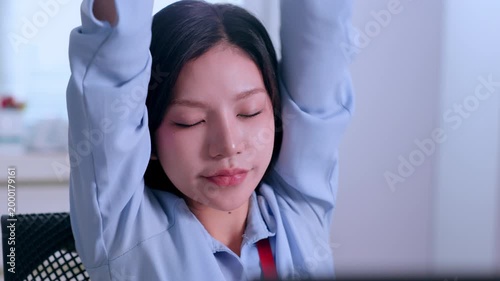 Sad shocked young asian businesswoman crying over unexpected terrible news at office desk then stretching arms feeling relaxed relieved tired comfortable during corporate job pause
