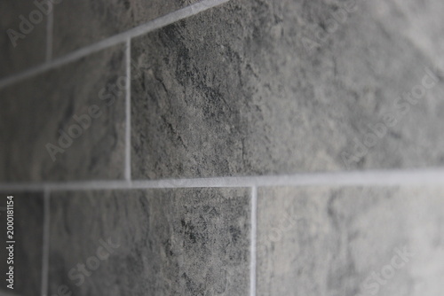Bild auf Leinwand Grey stone texture wall tiles with white grout lines close up