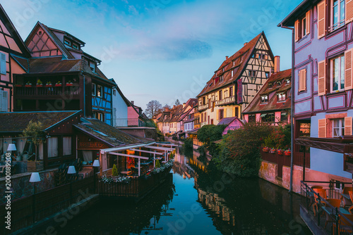 Silent Colmar canal at sunrise with violet sky and empty waterfront in Alsace France