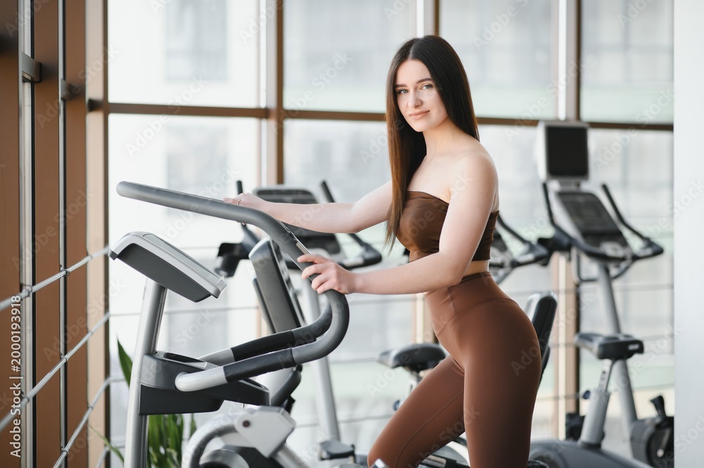 Fototapeta premium Young woman training at gym for fitness goals