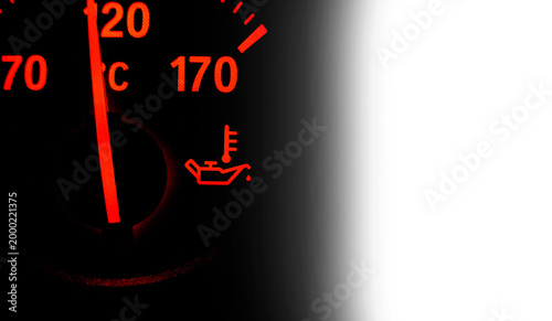 Engine oil temperature warning light on car dashboard isolated on black background with copy space