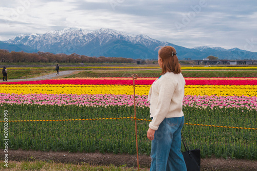 Woman Poses in Tulip Field with Mountains