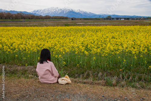 Girl in Yellow Flower Field with Mountains